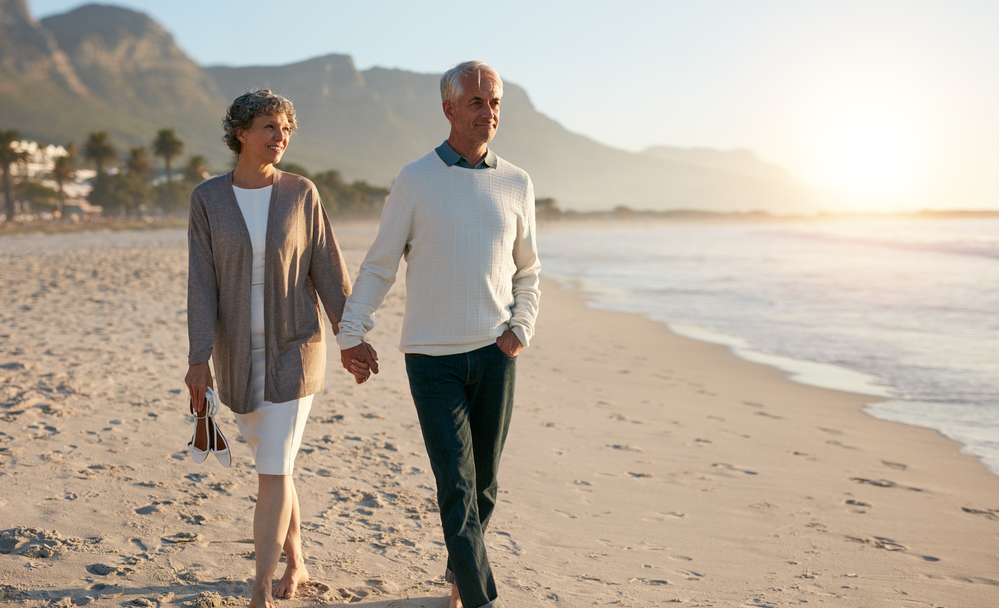 Senior relaxed couple walking on beach